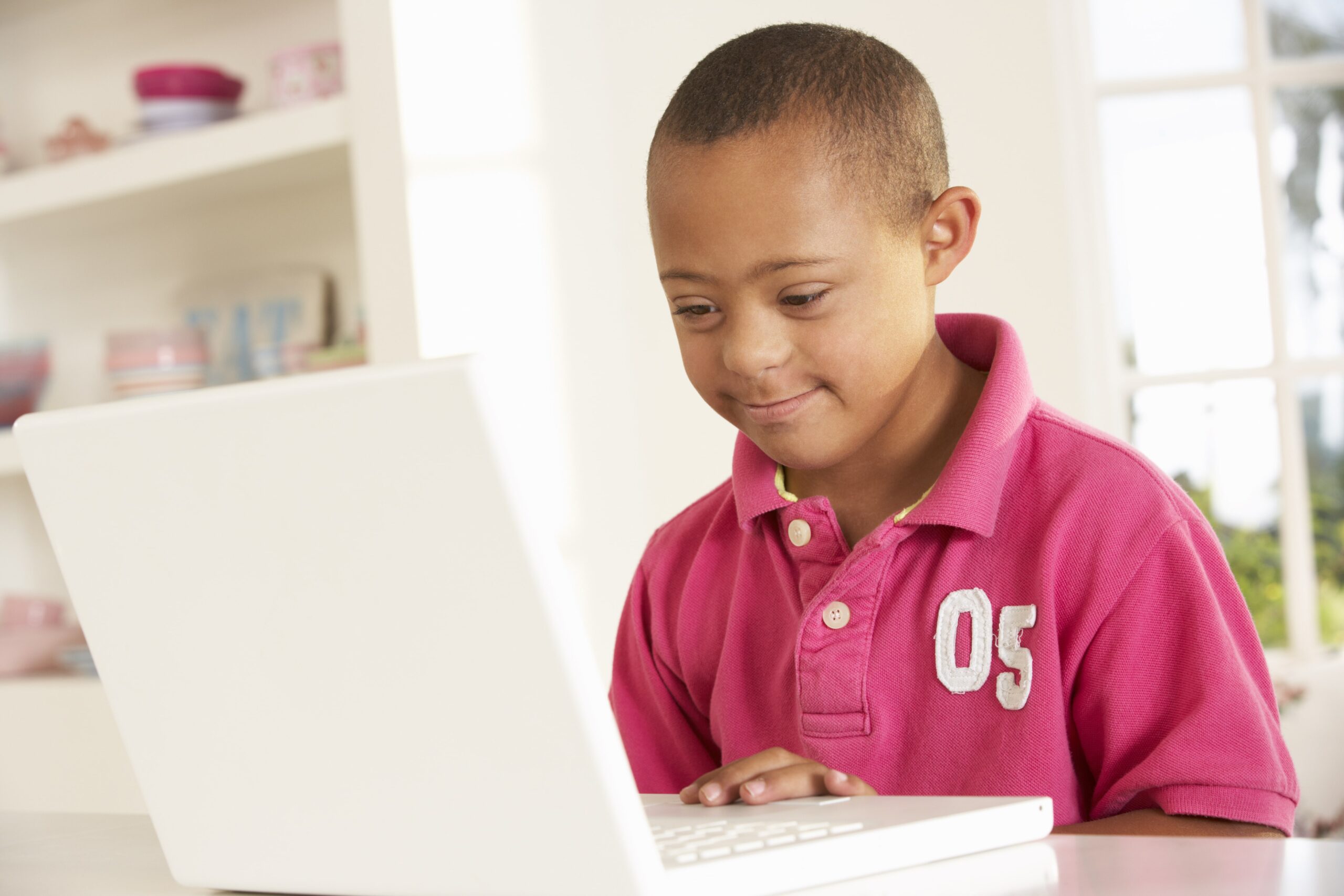 Young boy with down syndrome working on a computer